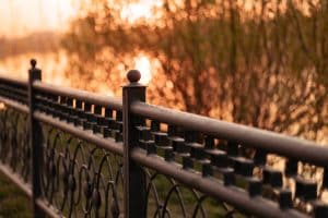 Metal black low fence in the park with a blurred background