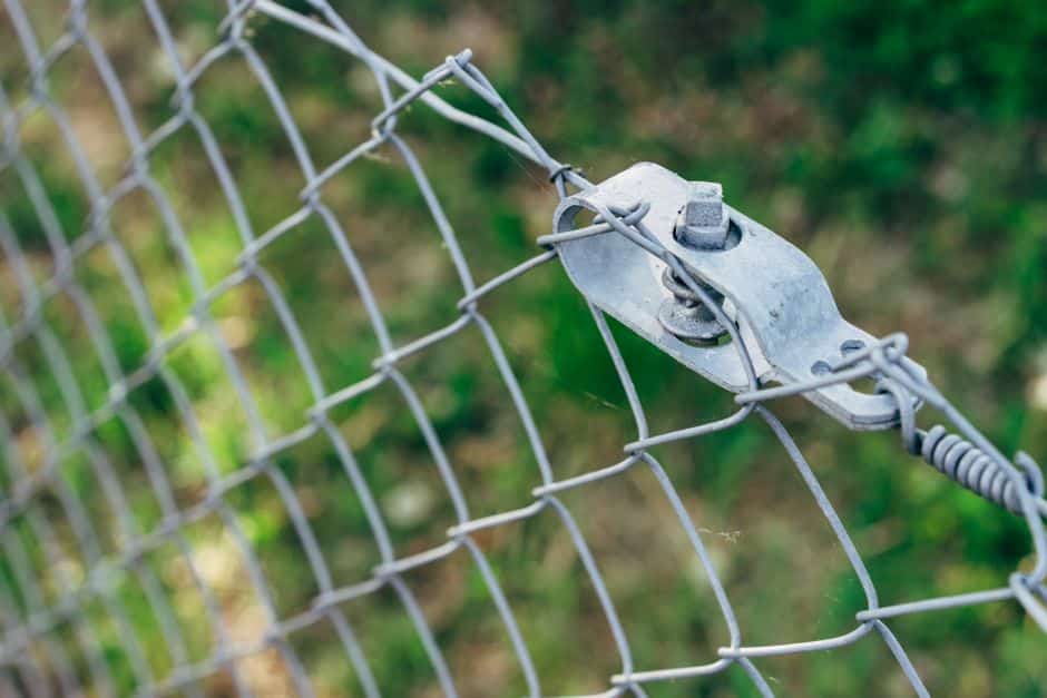 Close-up of aluminum fence post hardware checked during installation