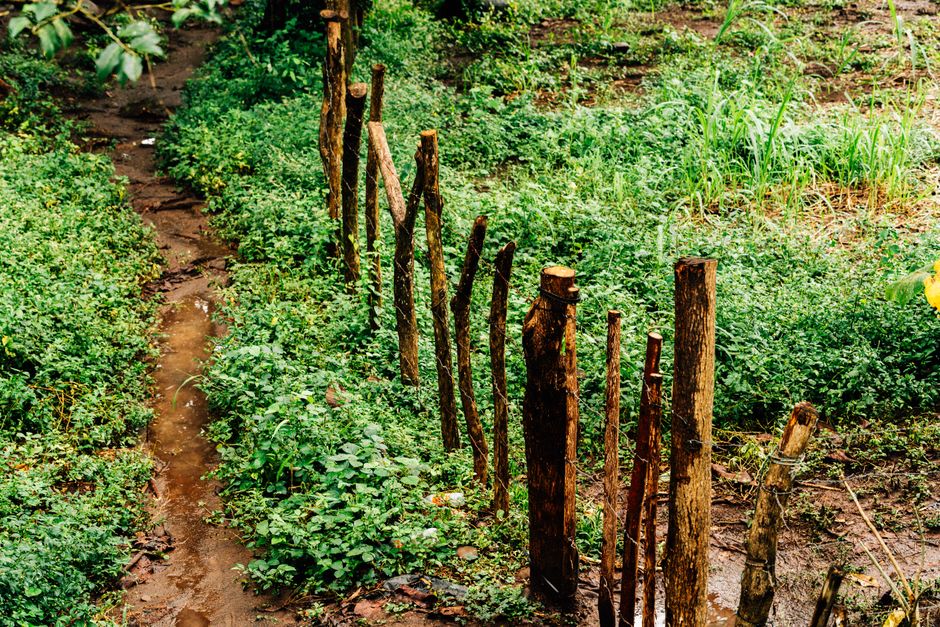 A fence post being set in New Orleans clay soil with a level and shovel nearby