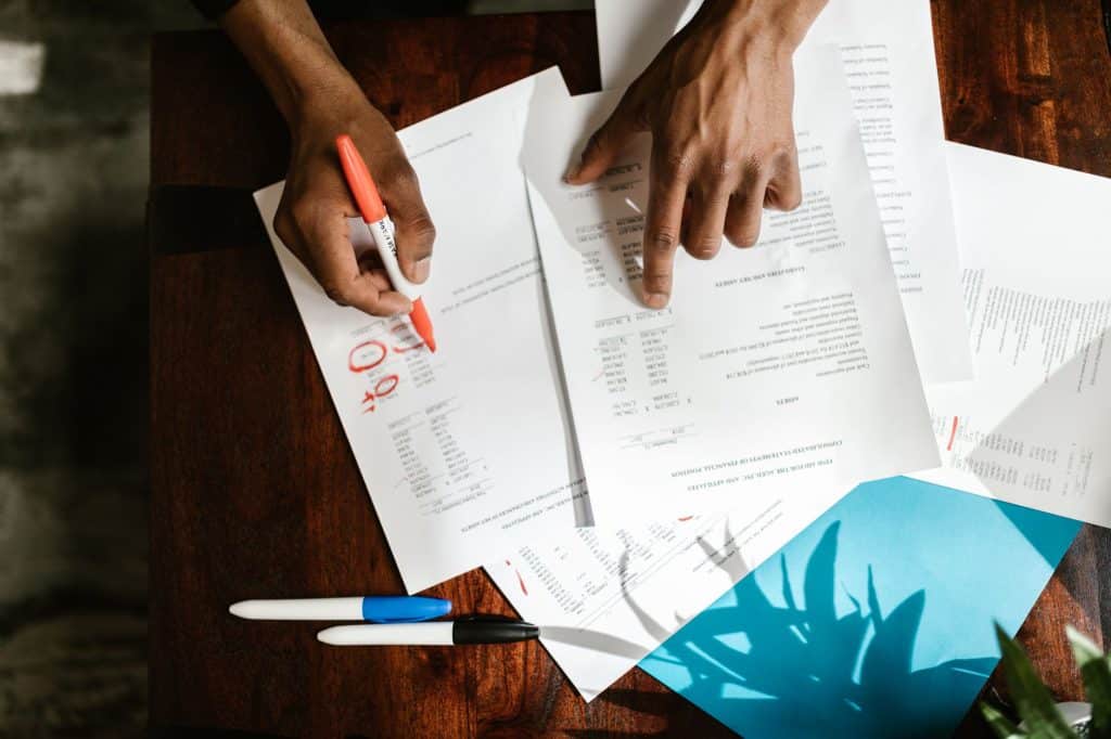 Homeowner reviewing a fence site plan and paperwork at a table