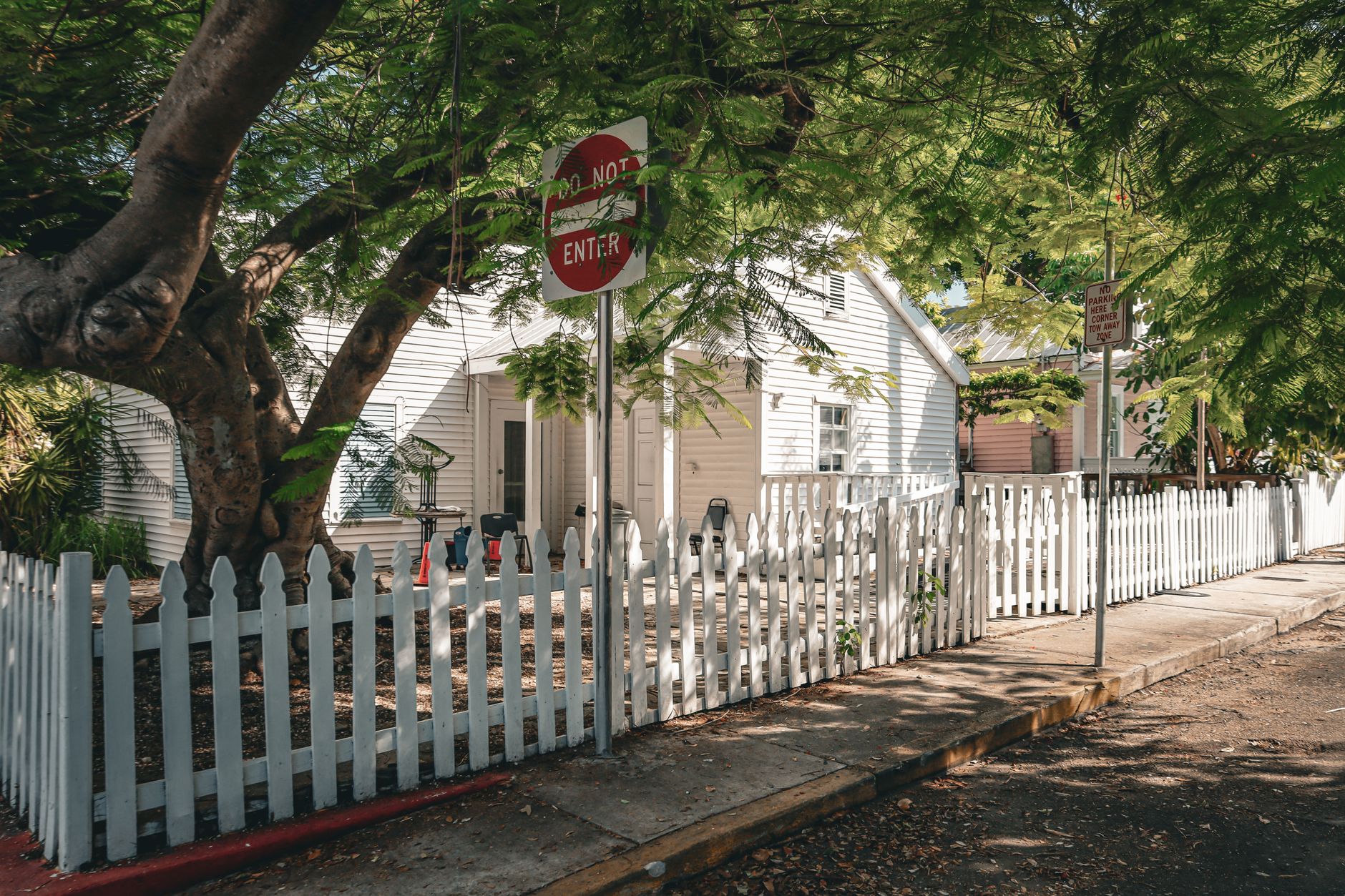 Beautiful house with a white picket fence and lush greenery in Key West, Florida.