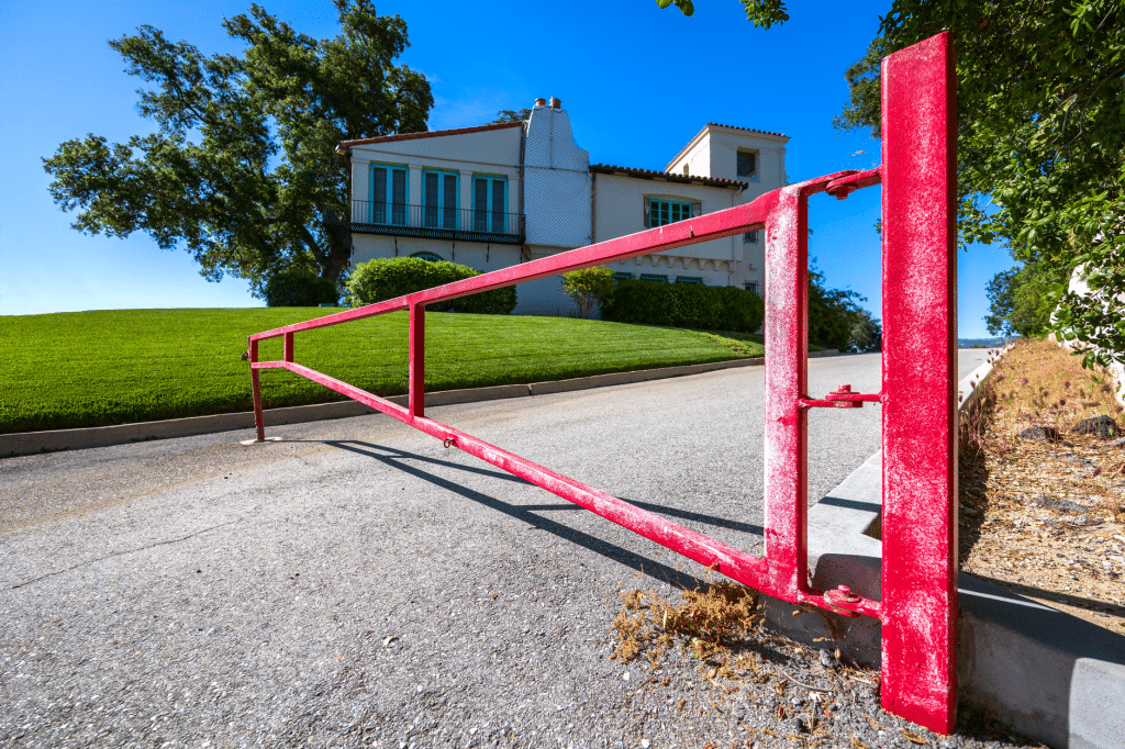 Swing style aluminum driveway gate opening on a New Orleans driveway