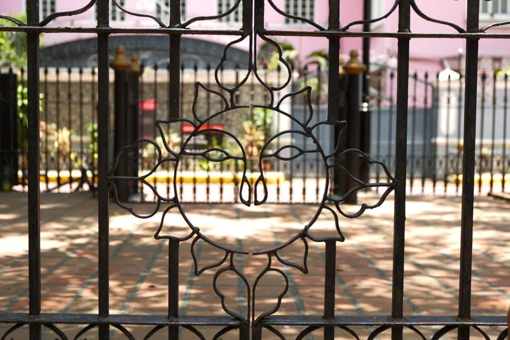 Wrought iron gate with arched top rail matching a historic New Orleans ironwork balcony