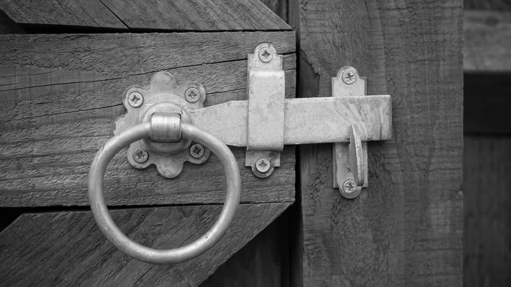 Wrought iron fence gate with a secure latch in a New Orleans yard